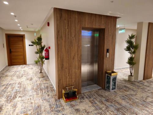 an office lobby with a elevator and potted plants at فندق سي قل - Sea gull Hotel in Umm Lujj