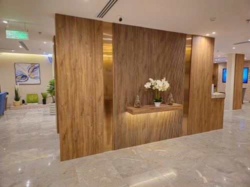 a lobby with wooden walls and flowers on a counter at SEAGULL HOTEl in Umm Lajj
