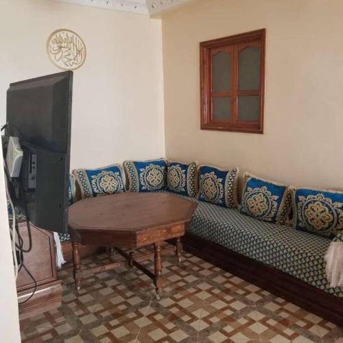 een woonkamer met een blauwe bank en een tv bij Berber house in Agadir