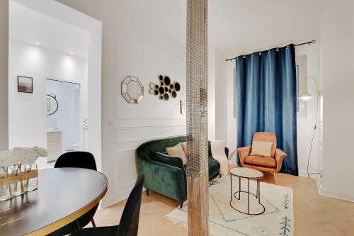 a living room with a green couch and a table at Beautiful apartment - Arc de Triomphe in Paris