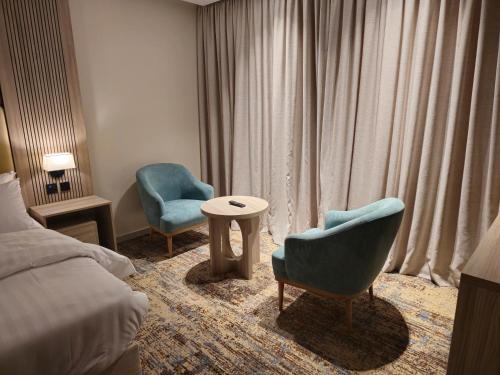 a hotel room with a bed and two chairs and a table at فندق سي قل - Sea gull Hotel in Umm Lujj