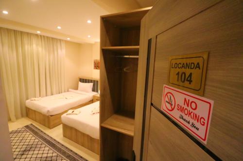 una habitación de hotel con 2 camas y una señal de no fumadores en Locanda Pyramids Hotel, en El Cairo
