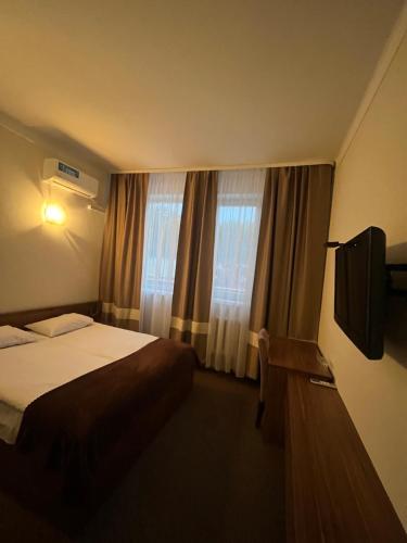 Hotel Sofiivka في Konopnitsa: غرفه فندقيه سرير وتلفزيون