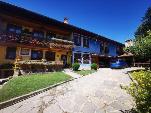 a house with flowers on the side of it at Hotel Rai in Koprivshtitsa