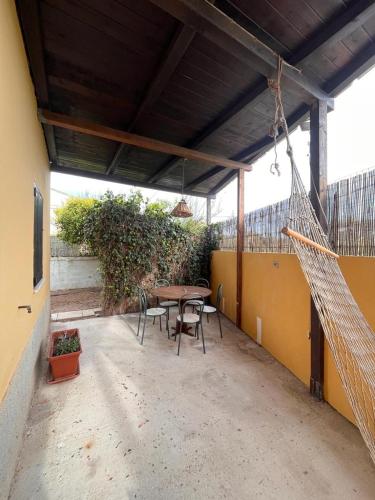 a patio with a table and chairs and a net at MER MAISON in Marina di Modica