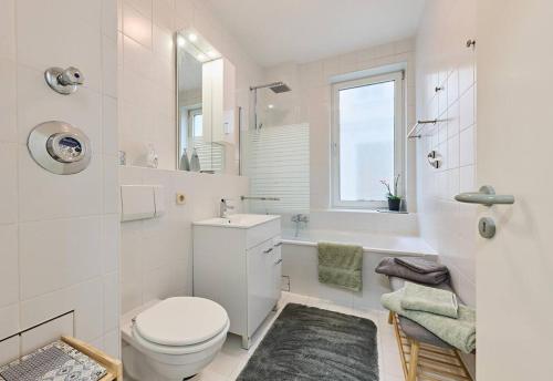 a white bathroom with a toilet and a sink at Schelfstadtoase in Schwerin