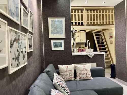 a living room with a blue couch and pictures on the wall at Apartment Marija- Kopaonik centar in Kopaonik