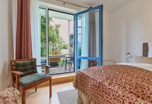 ein Schlafzimmer mit einem Bett, einem Stuhl und einem Fenster in der Unterkunft Schelfstadtoase in Schwerin