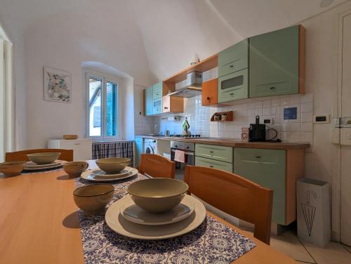 La Casa degli Alberi في دولشياكا: مطبخ مع طاولة عليها صحون