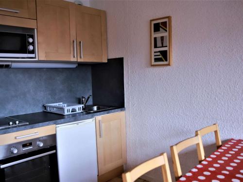 - une petite cuisine avec une table et un comptoir dans l'établissement Studio cabine rénové, grand balcon, 6 couchages, 300m des pistes d'Auris en Oisans - FR-1-297-34, à Auris
