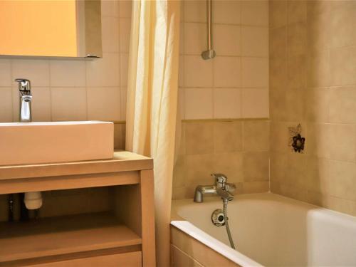 une salle de bain avec un lavabo et une baignoire dans l'établissement Studio cabine rénové, grand balcon, 6 couchages, 300m des pistes d'Auris en Oisans - FR-1-297-34, à Auris