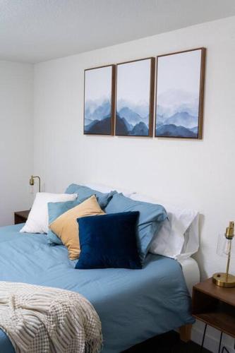 a bedroom with a blue bed with three windows at Modern Mountain Cabin - Spectacular Views at 3100 ft in Waynesville
