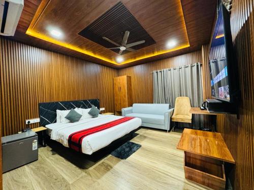 1 dormitorio con 1 cama, TV y sofá en N.K. Residency en Guwahati