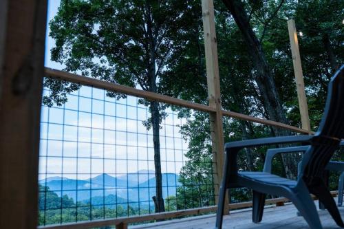 a view from a porch with a chair and a window at Modern Mountain Cabin - Spectacular Views at 3100 ft in Waynesville