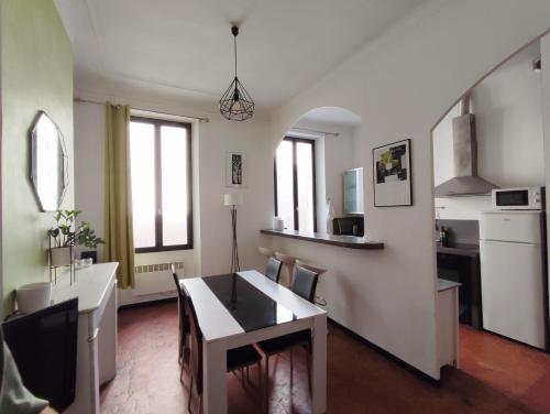 eine Küche und ein Wohnzimmer mit einem Tisch und Stühlen in der Unterkunft Appartement typique entre la Gare et la Canebière in Marseille