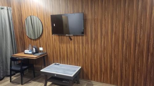 a room with a tv on a wooden wall at N.K. Residency in Guwahati