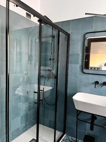 uma casa de banho com uma cabina de duche em vidro e um lavatório. em Residence La Torre em Acerenza