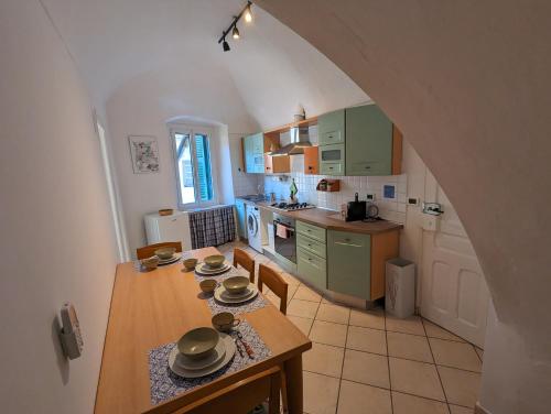 cocina con mesa y sillas en una habitación en La Casa degli Alberi, en Dolceacqua