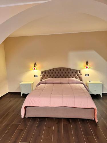 1 dormitorio con 1 cama grande y 2 mesitas de noche en Residence La Torre, en Acerenza