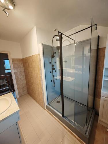 une douche en verre dans une salle de bain avec un lavabo dans l'établissement Belle maison proche de la plage, quartier calme, Audierne / Esquibien, à Audierne