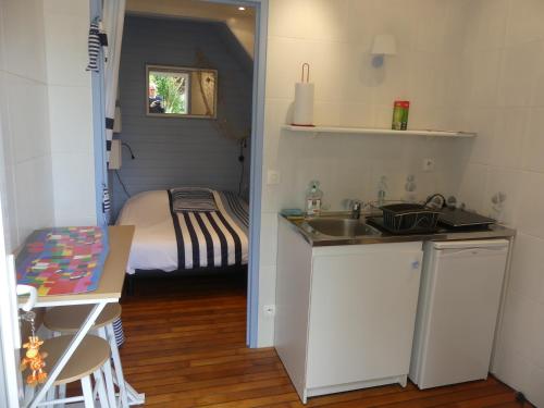 uma pequena cozinha com um lavatório e uma cama em Pony Sweet Home em Caen