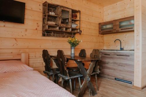 ein Esszimmer mit einem Tisch und Stühlen in einer Hütte in der Unterkunft Drevenice Horné Kysucé in Vysoká nad Kysucou