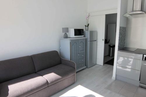 a living room with a couch and a microwave at Maison hôtes près de Disneyland Paris in Lagny