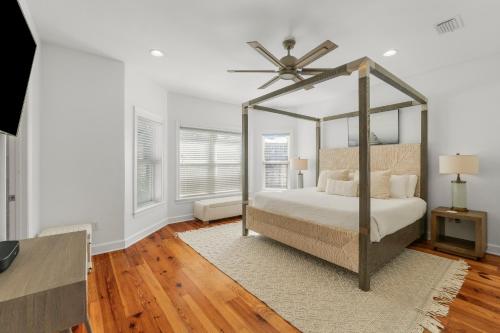 a bedroom with a canopy bed with a fan at Destin Beach House - Gulf Moon by Panhandle Getaways in Destin
