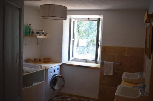 La salle de bains est pourvue d'un lave-linge et d'une fenêtre. dans l'établissement Mas du Pont, à Saint-Jean-de-Maruéjols-et-Avéjan