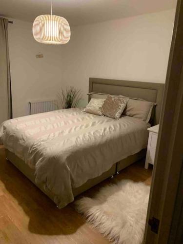 a bedroom with a bed with a white rug at Beautiful East London Flat in Barking