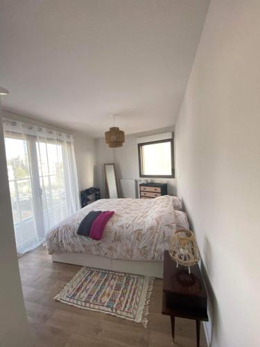 une chambre avec un lit, une table et des fenêtres dans l'établissement Appartement cosy avec Parking bordeaux, à Bordeaux