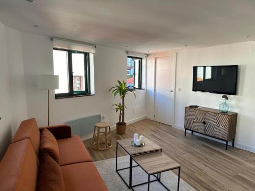 ein Wohnzimmer mit einem Sofa und einem Flachbild-TV in der Unterkunft CASA URBANIN III centro de cudillero in Cudillero