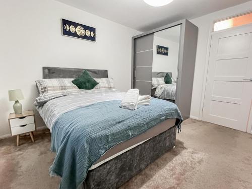een slaapkamer met een groot bed en een spiegel bij New Stylish 2-Bed Retreat in Central Windsor in Windsor
