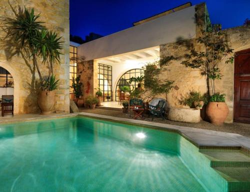 a swimming pool in front of a house at Historic Venetian Castle ideal for family events! in Maroulás