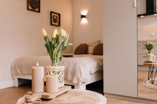 a room with a bed and a table with yellow flowers at Casa la Vida Beach House in Zandvoort