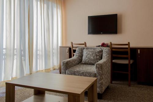 a living room with a chair and a television at Motel Calypso Travnik in Travnik
