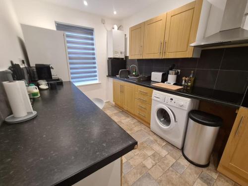 a kitchen with a washing machine in a kitchen at Split level luton town center flat in Luton
