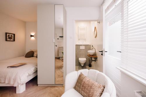 a small bedroom with a bed and a bathroom at Casa la Vida Beach House & Free Bikes in Zandvoort