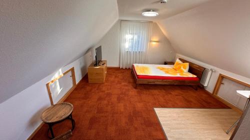 フリードリヒスハーフェンにあるPE Loft Centralの小さな屋根裏のベッドルーム(ベッド1台、テレビ付)