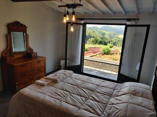 a bedroom with a large bed and a large window at Quinta Erva Doce in Vila do Porto