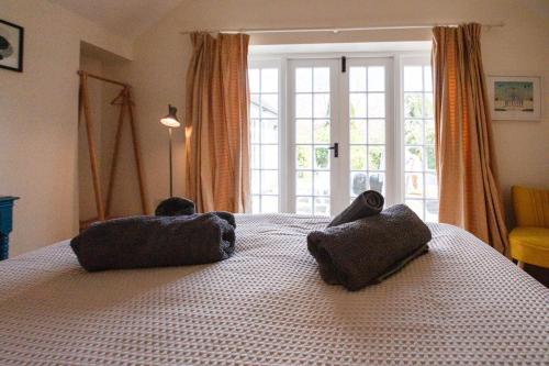 1 dormitorio con 1 cama con 2 almohadas en Post Office Cottage en Weymouth