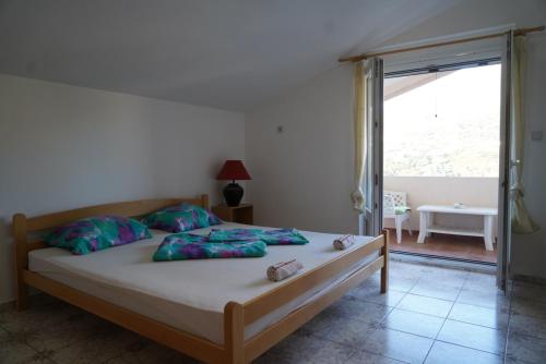 a bedroom with a bed and a sliding glass door at Apartments Safija in Dobra Voda