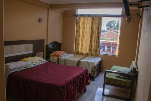 a small bedroom with two beds and a window at Alojamiento Tablada in Tarija