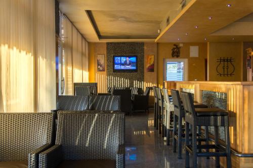 a dining room with chairs and a tv on the wall at Motel Calypso Travnik in Travnik
