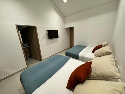 a hotel room with two beds and a tv at Casa Privada en Exclusivo Club Privado in Ricaurte