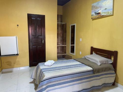 a bedroom with a bed and a flat screen tv at Pousada Cuiarana Salinas in Salinópolis