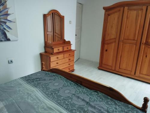a bedroom with a bed and a wooden cabinet at Sobe Popovica in Soko Banja