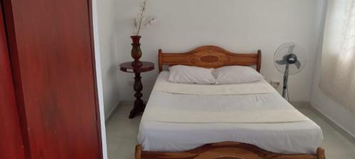um quarto com uma cama com cobertores brancos e almofadas em El hospedaje perfecto em Cali
