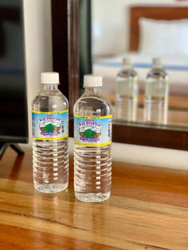 three bottles of water sitting on top of a table at Sand and Tan Beach Hotel in Ocho Rios