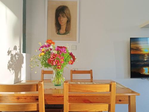 un jarrón de flores sentado sobre una mesa en Apartamento en la Playa - Alicante, Costa Blanca - Los Olivos, en Alicante